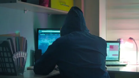 Male hacker internet working on a computer. man hacker in hood hiding indoor his Video stock 82572083