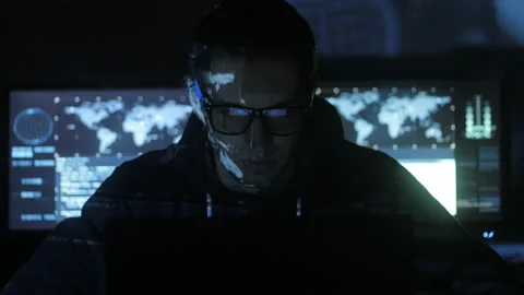 Male hacker programmer working at computer while blue code characters reflect on Stock-Footage 86883440