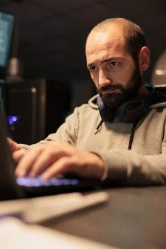 Male hacker using computer to break into corporate data Foto stock