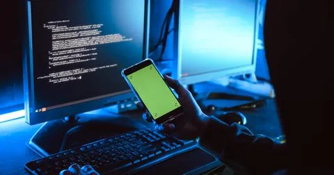 A male hacker is using a computer to hack data to demand ransom from victims. Stock Photos