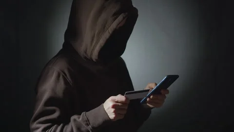 Male hacker using phone and credit card. Stock Footage 255324342