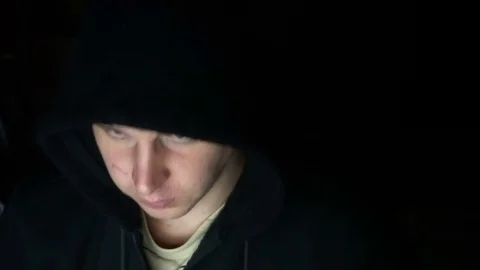 Male hacker working on a computer in a dark office room Video stock 77166845