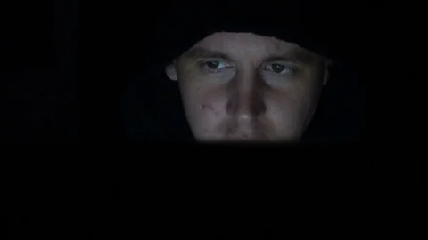 Male hacker working on a computer in a dark office room Stock Footage 77167273