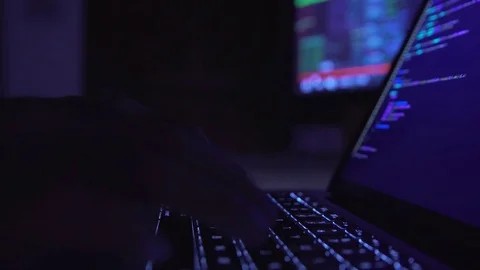 Male hacker working on a computer in a dark office room. Video stock 81055605