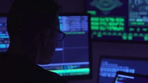 Male hacker working on a computer in a dark office room. Video stock 83191156