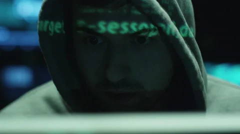 Male hacker working on computer while green code characters reflect on his face 스톡 동영상 59155793