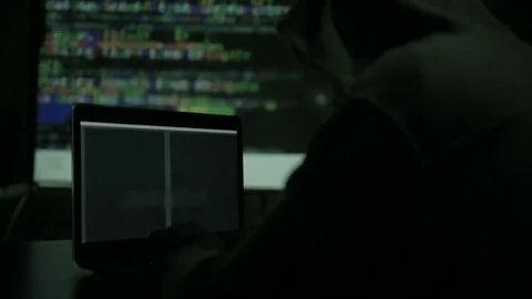 Male hacker working on a computer while green code characters reflect on his Stock Footage 84844792