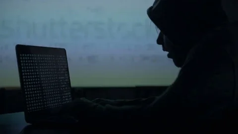 Male hacker working on a computer while green code characters reflect on his Stock Footage 84845764