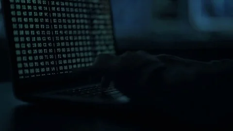 Male hacker working on a computer while green code characters reflect on his Stock Footage 84845867