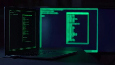 Male hacker working on a laptopi in a dark office room Stock Footage 71220498