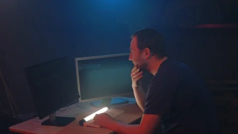 Male hacker works on a computer with data on display screens Stock Footage 90979720
