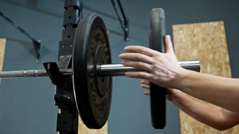 Male hand adding weights on barbell in gym. Close-up of hands. Muscle build. Video stock 273199621