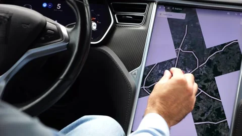 Male hand of businessman interacts with touchscreen of electric car displaying m Stock Footage 332872253