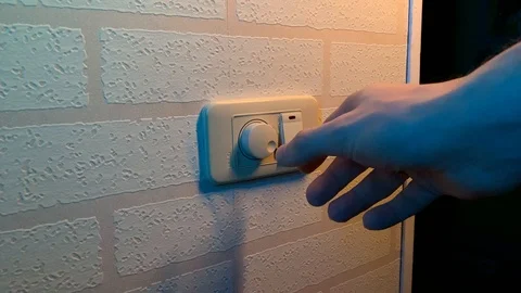 Male hand close-up rotates dimmer switch light switch Stock Footage 123790998