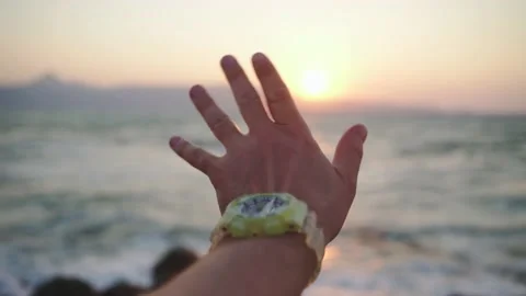 Male hand close-up at sunset, the rays of the setting sun Stock Footage 159586680