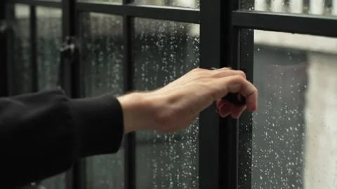 Male hand closing large window with a black frame in the veranda during the rain 스톡 동영상 294729384
