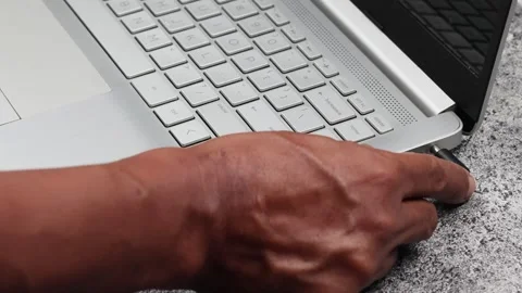 Male hand connecting the charging cable to the laptop Stock Footage 307004101