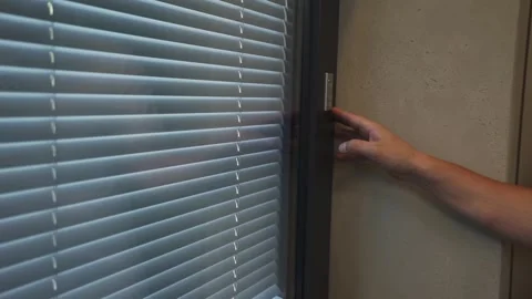 Male hand controls automatic blinds on window Stock Footage 276870343