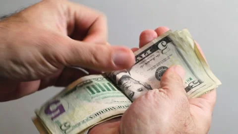 Male hand counting dollars banknotes. Selective focus of a man with American Stock Footage 201488866