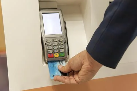 Male hand dials pin code on pin pad of card machine or pos terminal with inse Fotos de archivo