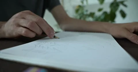 Male hand draw a drawing on sheet of paper. 4K 10-bit Stock Footage 345233477