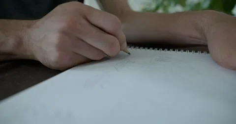 Male hand draw a drawing on sheet of paper. 4K 10-bit Stock Footage 345234566