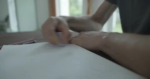Male hand draw a drawing on sheet of paper. 4K 10-bit Stock Footage 345234567