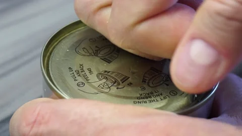 Male hand, finger pulls the ring and opens an aluminum can of canned sweet pe Stock-Footage 158326869