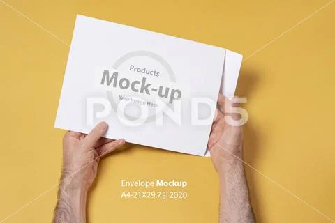 Male hand holding an A4 paper envelope mock-up series PSD Template