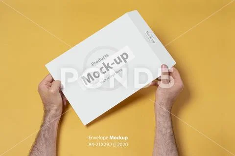 Male hand holding a C4-A4 paper envelope mock-up series Modello PSD