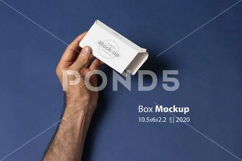 Male hand holding an empty pillbox in front of blue background mock-up series PSD Template