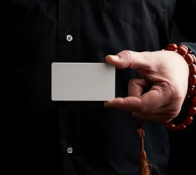 Male hand holding a rectangular blank white paper business card 写真素材