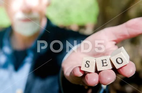 Male hand holding SEO lettering for website optimization and increase traffic Stock Photos