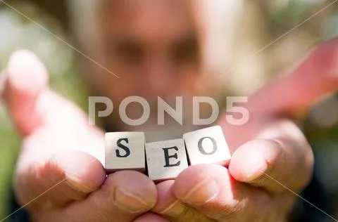 Male hand holding SEO lettering for website optimization and increase traffic Stock Photos