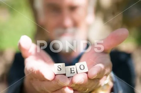 Male hand holding SEO lettering for website optimization and increase traffic Stock Photos