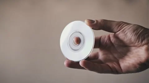 Male Hand Holding Small Compact Disc with Rainbow Reflections Stock Footage 329910685