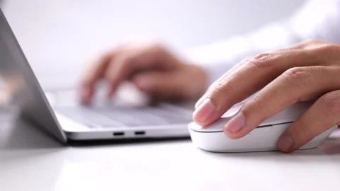 The male hand holds a computer mouse and typing laptop keyboard. Stock-Footage 166103102