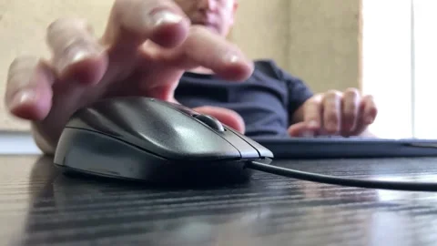 A male hand holds a computer mouse. Computer mouse close-up, fingers clicking Stock Footage 247010776