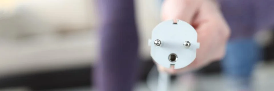 Male hand inserting plug into socket at home closeup Stock Photos