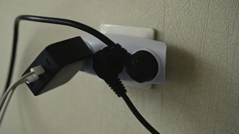 Male hand inserting power plug into white tee outlet connected to wall socket Stock Footage 312233524