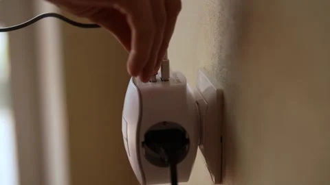 Male hand inserting usb cable into white wall socket adapter featuring multiple Stock Footage 290072612