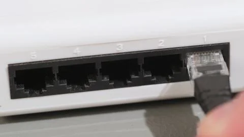 Male Hand Inserts The Blue Data Lan Cable rj45 Into Network Switch in Data Foto stock