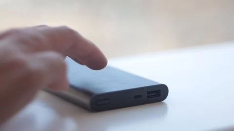 Male hand inserts cable from portable charging Stock Footage 99569606
