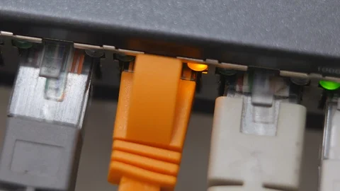 Male Hand Inserts The Orange Data Cable Into The Gigabit Network Switch. Stock Footage 104923716