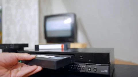 Male hand inserts VHS cassette into the player. Man presses the button Stock Footage 319890436