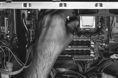 Male hand installs an Intel processor in the socket Stock Photos