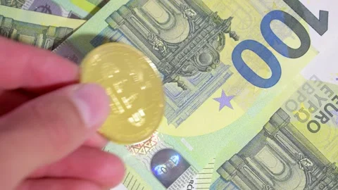 Male Hand Laying Down Single Golden Bitcoin On Stack Of Hundred Euro Stock Footage 138124812