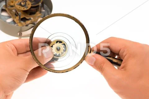The male hand with magnifier and clockwork Stock Photos