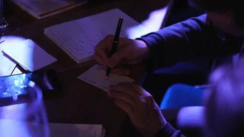 The male hand makes an entry in the notebook. Writing to notebook Stock Footage 129112841