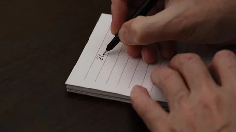 Male hand in notebook writes numbers new year 2025 with pen and emphasizes them. Video stock 295111483